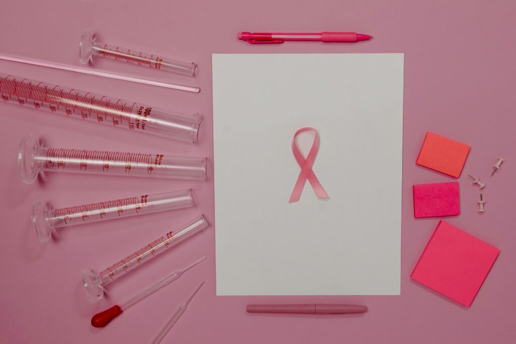 Pink ribbon and lab equipment symbolize breast cancer awareness and research.